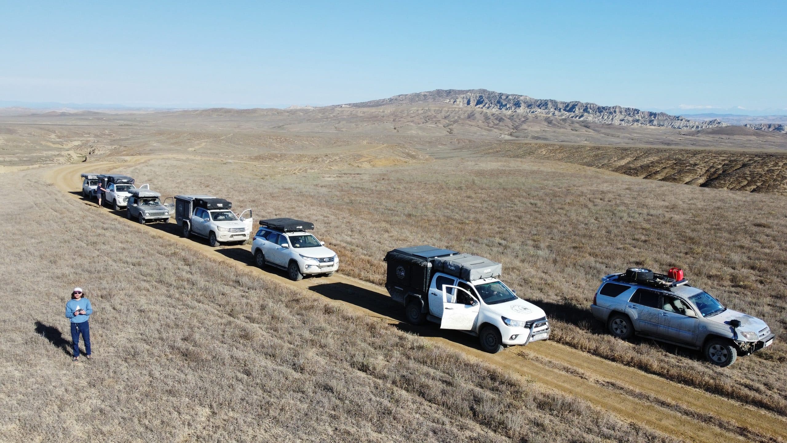 A convoy of 4x4 vehicles crossing the steppe